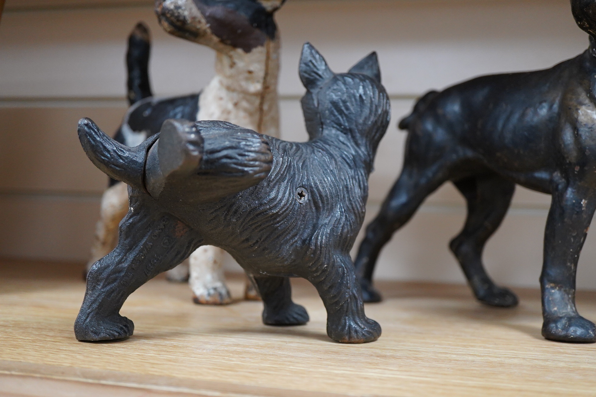 A group of three painted metal dogs, largest 25cm high x 23cm wide